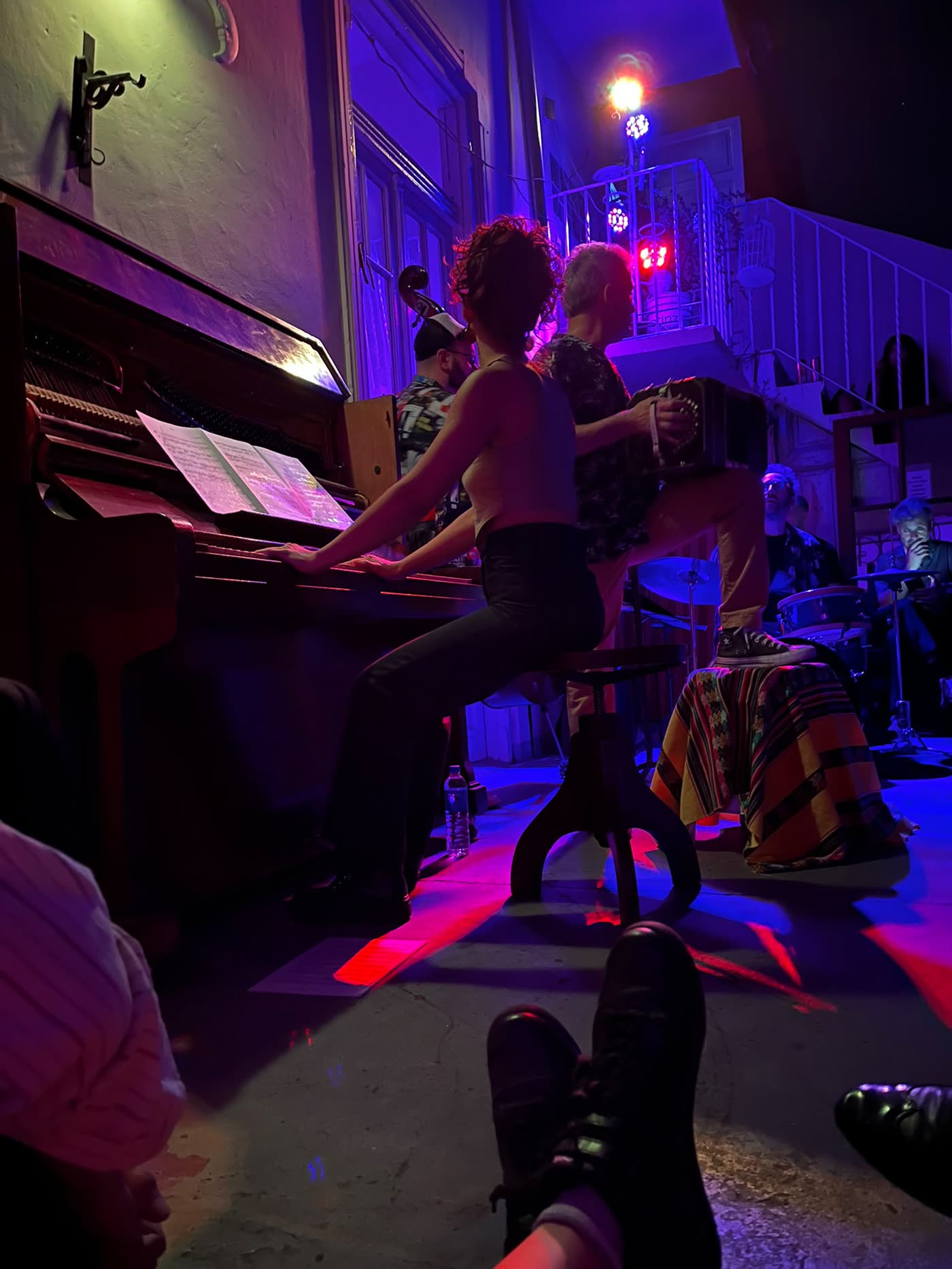 The pianist seen from the floor, dancers' shoes in the foreground